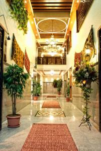 a hallway with plants and rugs in a building at Jardaneh Hotel in Aqaba