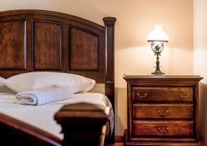 アヴェモナスにあるAvlemonas Luxury Houseのベッドルーム1室(ランプとドレッサー付きのベッド1台付)
