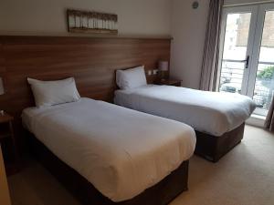 um quarto de hotel com duas camas e uma janela em Riverside Hotel em Sligo