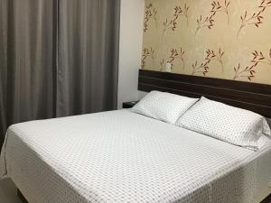 a bedroom with a bed with a white comforter at Condomínio Palm Beach in Aquiraz +35 photos