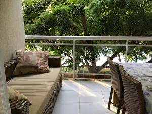 a porch with two wicker chairs and a window at Condomínio Palm Beach in Aquiraz