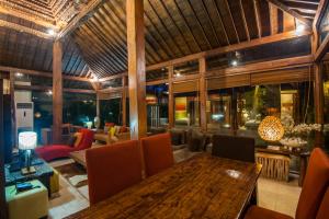 a dining room with a wooden table and chairs at Tides Echo Beach in Canggu
