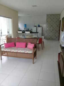 Casa Praia Luís Correia في لويس كوريا: غرفة معيشة مع أريكة عليها وسائد وردية