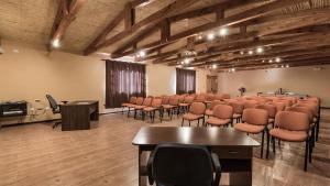 une salle de conférence avec des chaises, une table et un podium dans l'établissement Hotel Casa Don Esteban, à San Pedro de Atacama