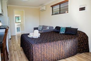 a bedroom with a large bed and a couch at The Gallery Motor Inn in Dalby