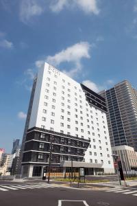 a large white building on a city street at Daiwa Roynet Hotel Nagoya Nayabashi in Nagoya