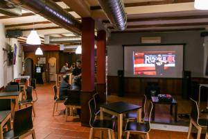 a restaurant with people sitting at tables and a projection screen at Residencial Gil Vicente in Sardoal