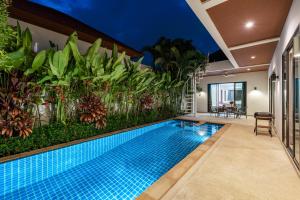 einen Pool in einem Haus mit Garten in der Unterkunft Modern 3br Boutique Pool Villa by Intira Villas in Rawai Beach