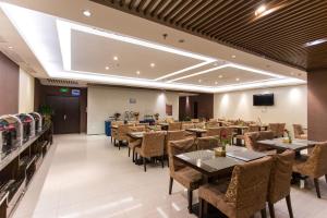 a restaurant with tables and chairs and a flat screen tv at Metropolo, Langfang, Wanda Plaza-Ningyuan Park in Langfang