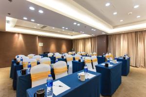 a conference room with blue tables and chairs and water bottles at Metropolo, Langfang, Wanda Plaza-Ningyuan Park in Langfang