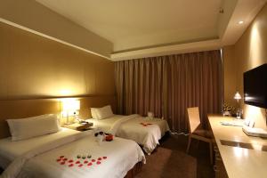 a hotel room with two beds and a television at Metropolo, Langfang, Wanda Plaza-Ningyuan Park in Langfang +22 photos