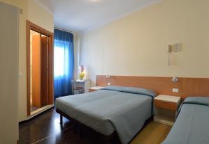 a small bedroom with a bed and a window at Hotel Guya in Varazze