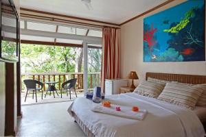 a bedroom with a bed and a balcony with a view at El Galleon Beach Resort in Puerto Galera