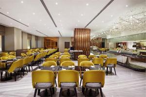 a restaurant with yellow chairs and tables in a room at Dorsett Residences Bukit Bintang @Dorsett Kuala Lumpur in Kuala Lumpur