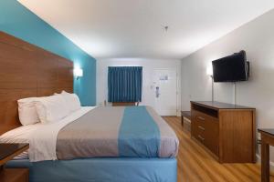 Una habitación de hotel con una cama y un televisor de pantalla plana. en Motel 6-Albany, GA, en Albany
