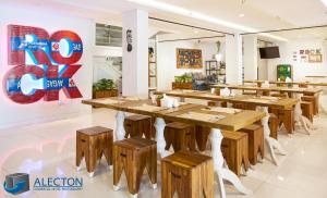 a restaurant with wooden tables and wooden stools at Rock Hotel in Krukah