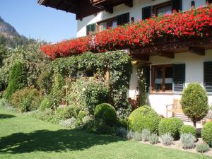 Una casa con flores rojas al costado. en Ferienwohnung Frenner, en Sankt Martin bei Lofer