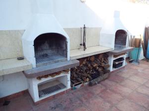 two outdoor brick ovens with a pile of wood at Villa More in Monteroni di Lecce