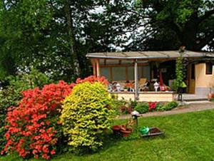 ogród z czerwonymi kwiatami i altaną w obiekcie Haus Grüllich w mieście Rathmannsdorf