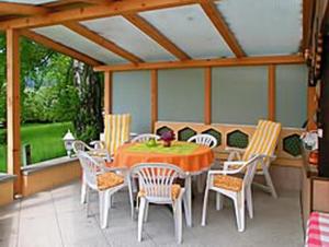 eine Terrasse mit einem Tisch und Stühlen auf einer Veranda in der Unterkunft Haus Grüllich in Rathmannsdorf