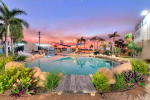 a large swimming pool with a wooden bridge in a resort at Discovery Parks - Townsville in Townsville