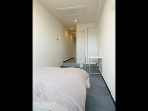 - une chambre avec un lit blanc et un bureau dans l'établissement Nagoya Motoyama House D, à Nagoya