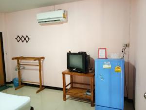 a room with a television and a small refrigerator at Sakthong Resort in Sawankhalok