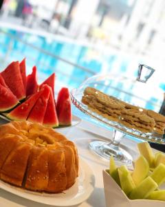 Garni Hotel Hollywoodland Wellness & Aquapark في بلغراد: طاولة مع صحن من الخبز والفواكه