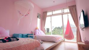 平和村的住宿－晴天裡飛翔莊園，粉红色的卧室设有两张床和窗户