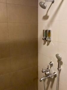 a shower stall with a shower head and a shower at Sai Towers in Puttaparthi