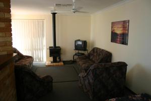 a living room with two chairs and a television at Denison Waterfront in Port Denison