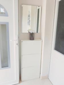 a white refrigerator in a room with a mirror at Apartment Brane in Solin