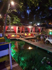 a pool at night with people sitting around a tent at Arikanda River Garden Hotel in Adrasan
