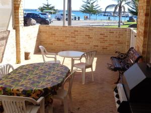 a table and chairs on a patio with a table and a table and chairs at Denison Waterfront in Port Denison