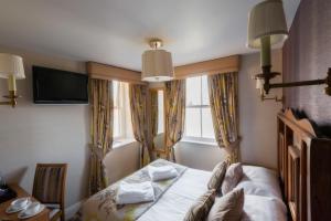 a hotel room with a bed and a window at Wagon & Horses in Lancaster