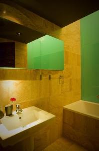 a bathroom with a sink and a green mirror at Ivana Apart Hotel in Oradea