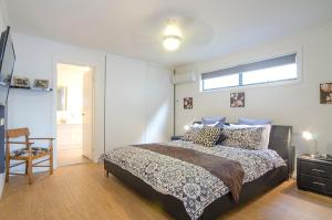 Un dormitorio con una cama grande y una ventana. en Seagrass Villas Normanville, en Normanville