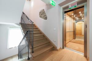 un escalier dans un bâtiment avec un panneau sur le mur dans l'établissement Albergo Parigi, à Arsiè