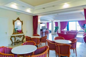 a restaurant with tables and chairs and a mirror at Hotel Executive La Fiorita in Rimini