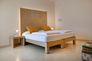 a bedroom with a large bed with a wooden headboard at Hotel Garnì Orchidea in Malcesine