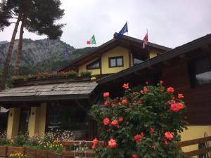 ein Gebäude mit Blumen und Flaggen darüber in der Unterkunft Hotel Cà Fiore in Bardonecchia