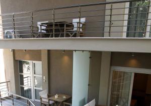 einen Balkon mit einem Tisch und Stühlen auf einem Gebäude in der Unterkunft Katrine Boutique Apartments in Kavala