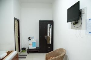 ein Wohnzimmer mit einem TV und einem schwarzen Schrank in der Unterkunft New Season Riverside Hotel in Phnom Penh