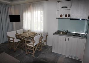 a kitchen with a table and chairs and a sink at Katrine Boutique Apartments in Kavála