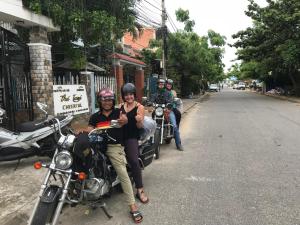 un gruppo di persone che cavalcano motociclette lungo la strada di Cheerful Hoi An Hostel a Hoi An