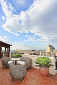 a patio with chairs and a table on a roof at Kastro Hotel in Heraklio