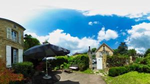 a patio with an umbrella and a house at La Maison du Notaire Royal in Sarlat-la-Canéda