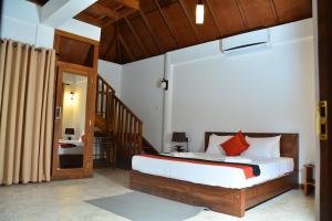 a bedroom with a large bed and a staircase at The Bell Farm Eco Resort in Sigiriya