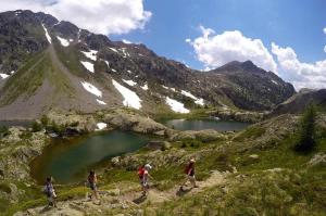 a group of people walking on a mountain with a lake at Blaise 4 pieces in Saint-Étienne-de-Tinée