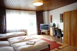 a hotel room with two beds and a television at St. Jobser Hof in Würselen